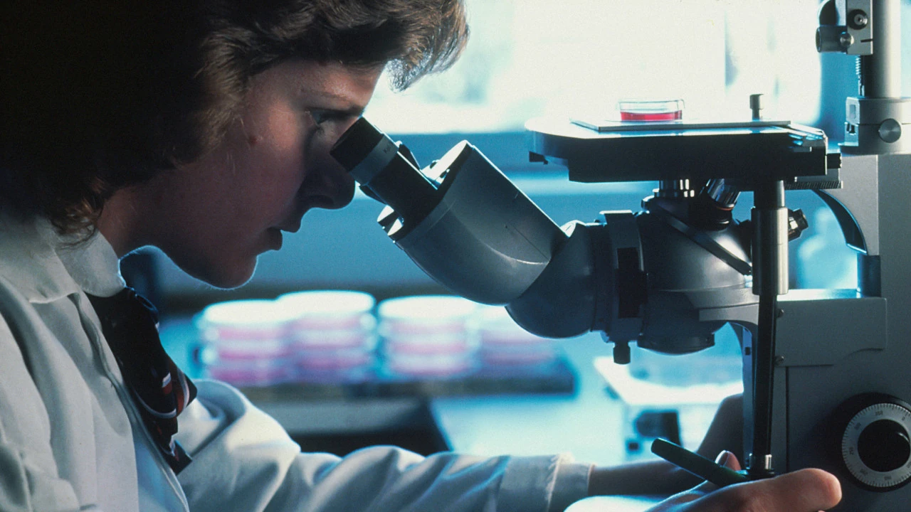 Científico usando un abrigo de laboratorio y mirando en un microscopio.